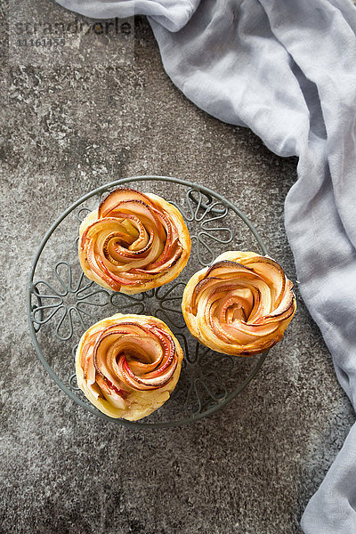 Filo pastry apple cakes in rose shape on cooling grid
