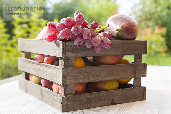 Holzkiste mit verschiedenen Früchten