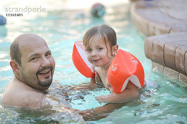 Porträt von Vater und kleiner Tochter zusammen im Schwimmbad