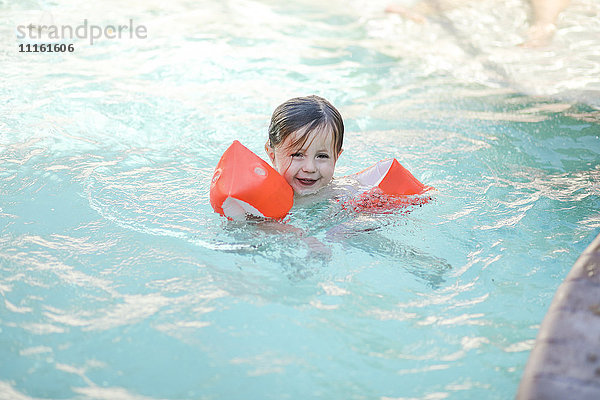 Kleines Mädchen mit schwimmendem Reifen im Schwimmbad