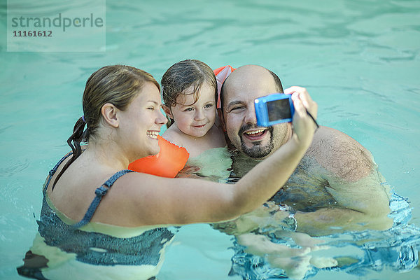 Familie  die sich selbst im Schwimmbad mitnimmt