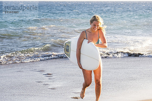 Spanien  Teneriffa  junge blonde Surferin am Strand