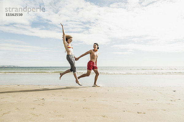 Glückliches Teenager-Paar am Strand