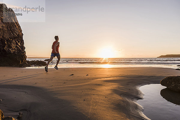 Frankreich  Halbinsel Crozon  Jogger am Strand bei Sonnenuntergang