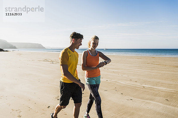 Frankreich  Halbinsel Crozon  sportliches junges Paar beim Spaziergang am Strand
