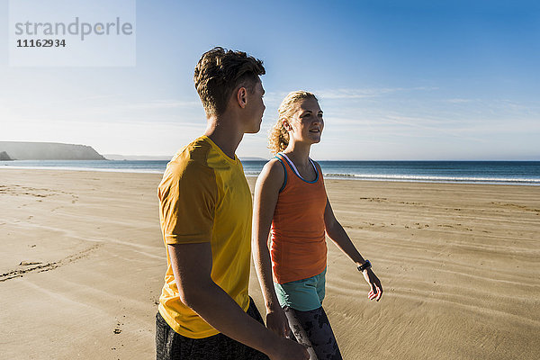 Frankreich  Halbinsel Crozon  sportliches junges Paar beim Spaziergang am Strand