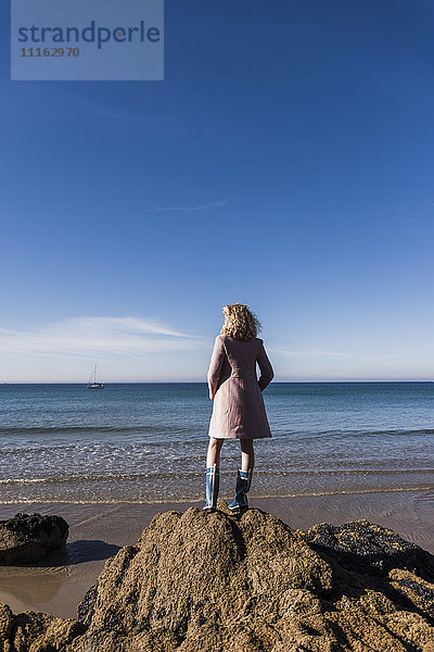 Frankreich  Halbinsel Crozon  Teenagermädchen auf Felsen am Strand stehend