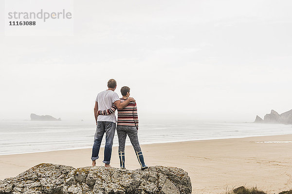 Frankreich  Bretagne  Halbinsel Crozon  Paar auf Felsen am Strand stehend