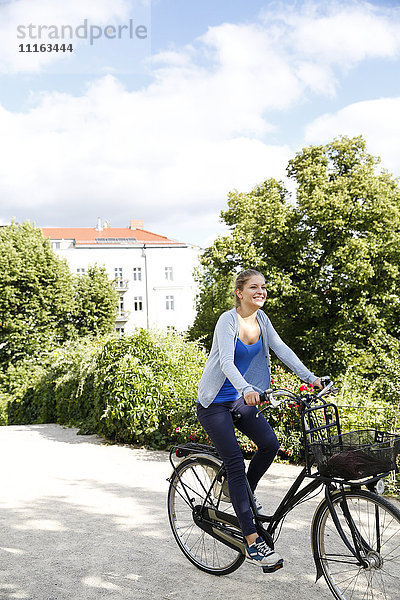 Junge Frau beim Fahrradfahren im Park