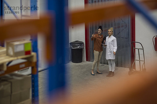 Two women talking in warehouse