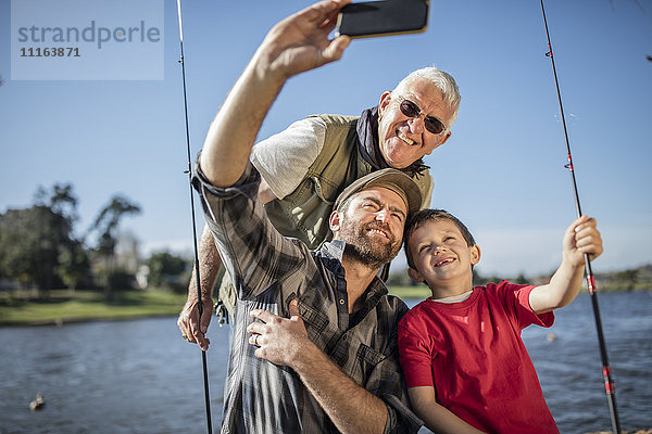 Großvater  Vater und Sohn nehmen einen Selfie mit Angelruten mit.