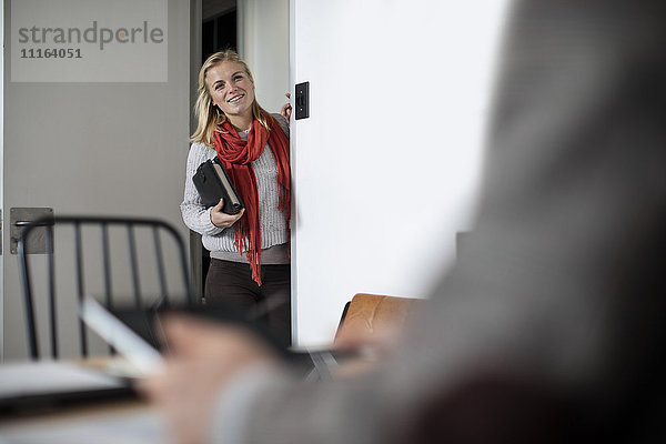 Junge Frau mit Notizbuch stehend im Amt