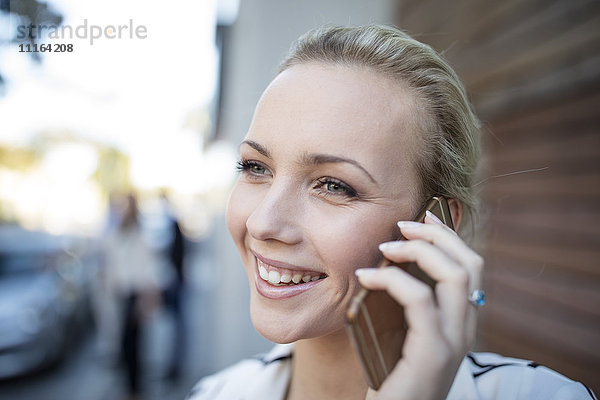 Lächelnde Frau spricht am Handy