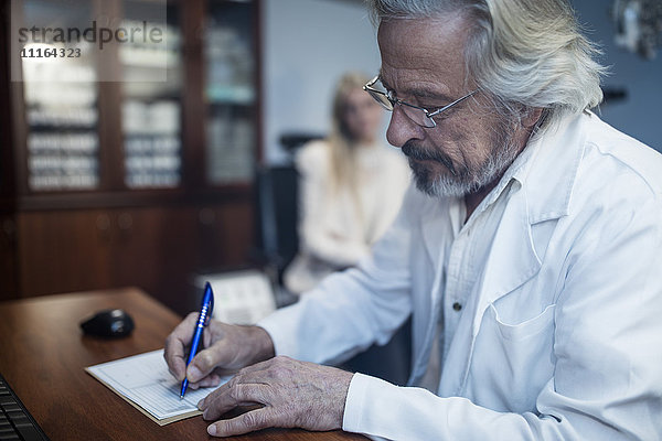 Ophtalmologe beim Schreiben der Patientenakte