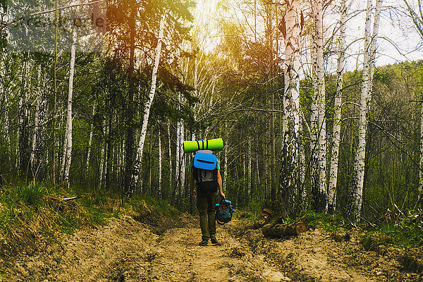 Kaukasischer Mann beim Rucksacktourismus im Wald