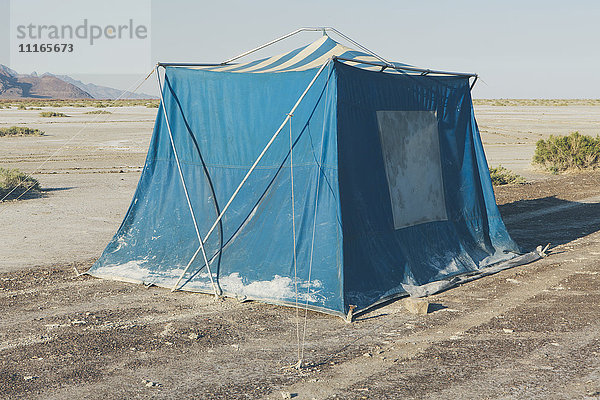 Altes schlammiges blaues Campingzelt in der Wüste der Bonneville Salt Flats.