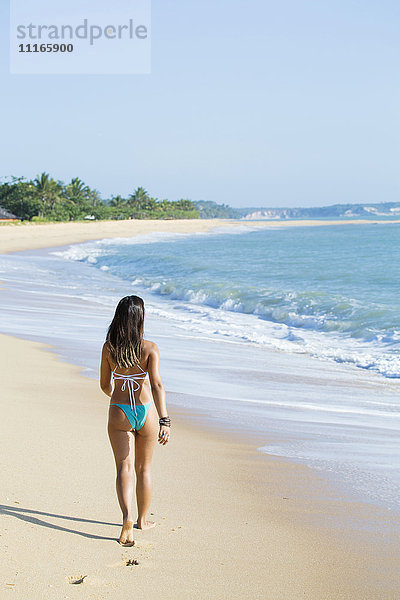 Gemischtrassiges Mädchen geht am Strand