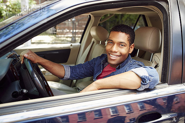 Lächelnder Mann posiert im Autofenster