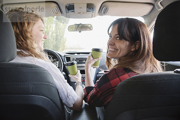 Zwei Frauen in einem Auto auf einer Autoreise. Blick von hinten.