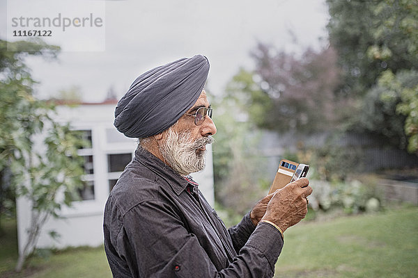 Indischer Mann schreibt eine SMS mit seinem Handy