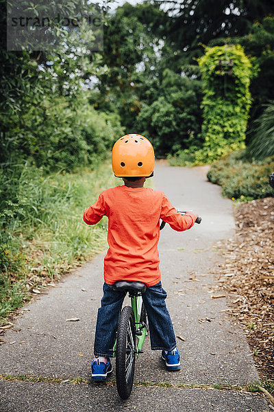 Schwarzer Junge auf Fahrrad mit Helm