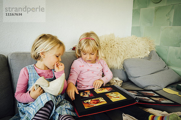 Kaukasische Mädchen schauen sich ein Fotoalbum an