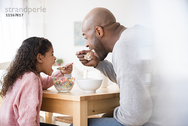 Vater und Tochter essen Müsli am Tisch