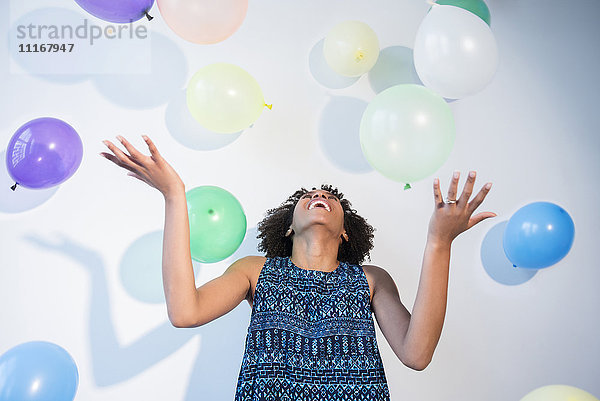 Schwarze Frau beobachtet fallende Ballons
