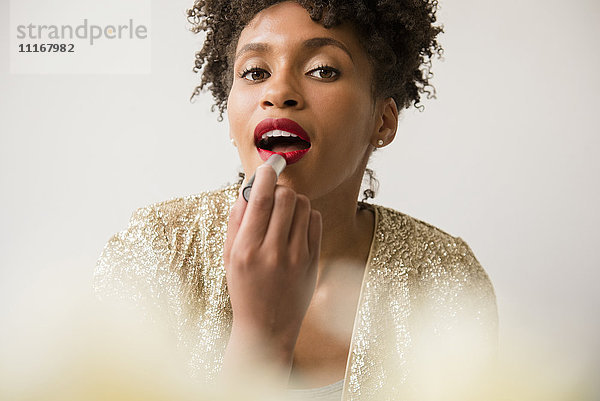 Glamouröse schwarze Frau trägt roten Lippenstift auf