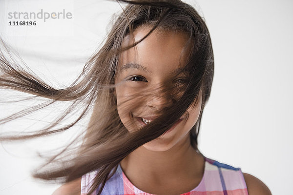 Wind weht Haar von lächelnden Mixed Race Mädchen