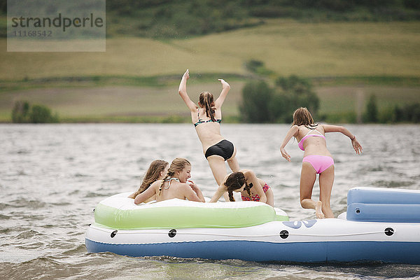 Teenager-Mädchen in einem Schlauchboot auf einem See.