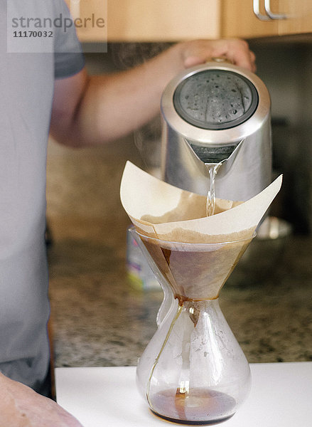 Familie bereitet das Frühstück in einer Küche vor  Mann macht Kaffee.