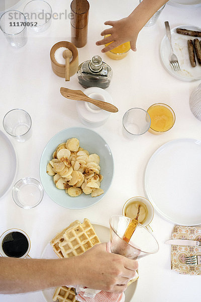 Hochwinkelaufnahme eines Frühstückstisches  Waffeln  Bratkartoffeln  Kaffee und Saft.