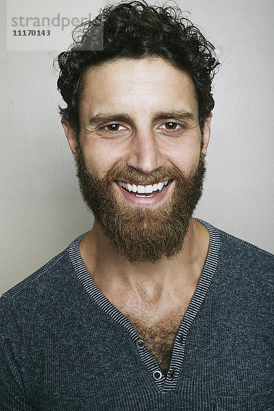 Lächelnder kaukasischer Mann mit Bart  der in die Kamera schaut
