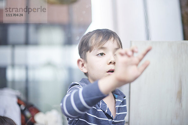 Hispanischer Junge berührt Fenster