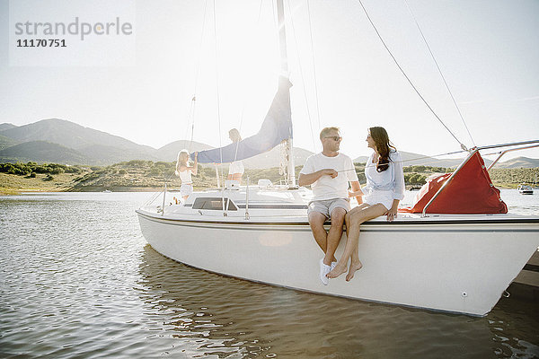 Mann und Frau sitzen auf einem Segelboot.