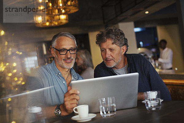 Männer benutzen Laptop im Restaurant