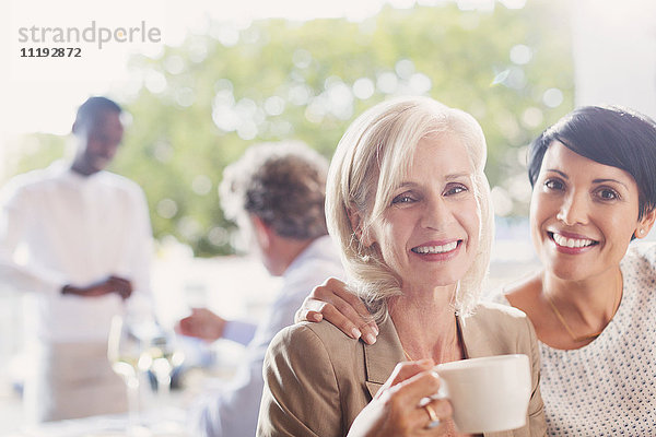 Porträt lächelnd Mutter und Tochter trinken Kaffee im Restaurant