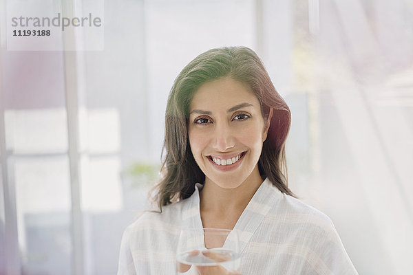 Porträt lächelnde brünette Frau trinkt Wasser