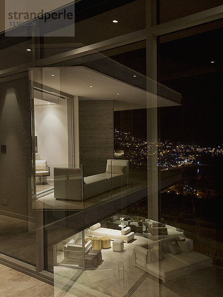 Beleuchtetes Schaufenster einer modernen Luxuswohnung bei Nacht