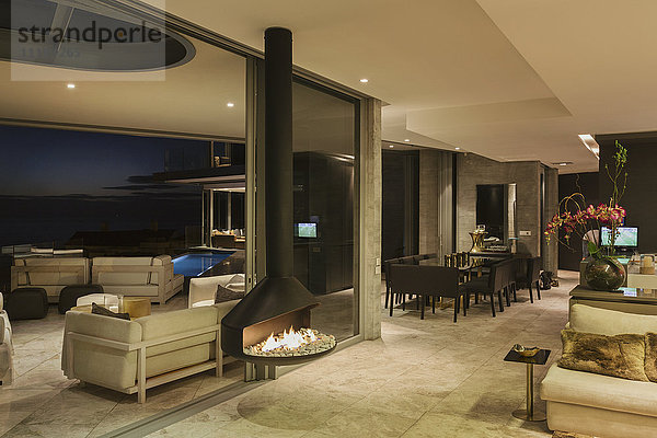 Beleuchtetes modernes Luxus-Wohnungsschaufenster mit hängendem Kamin