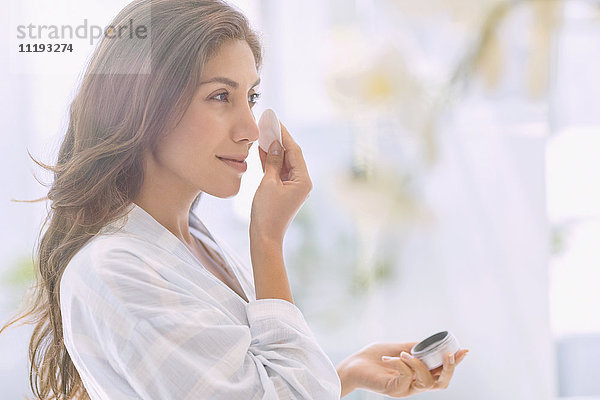 Brünette Frau trägt Make-up auf