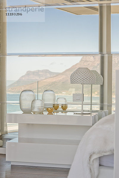 Moderner luxuriöser Nachttisch und Dekoration in einem Musterschlafzimmer mit Blick auf das Meer und die Berge