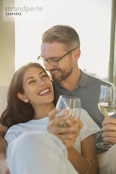 Verliebtes Paar lächelt und trinkt Weißwein