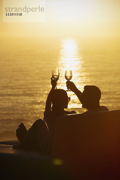 Silhouette Paar Toasting Weingläser auf Balkon mit ruhigen Sonnenuntergang Meerblick