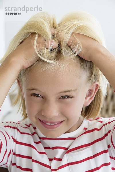 Nahaufnahme eines kleinen Mädchens beim Haarkratzen