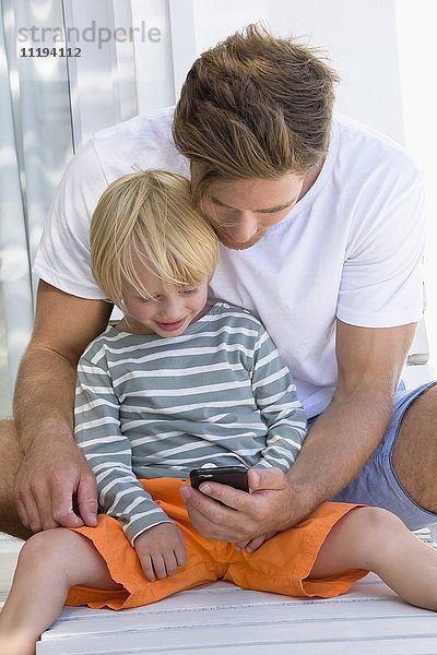Glücklicher Vater und Sohn am Telefon