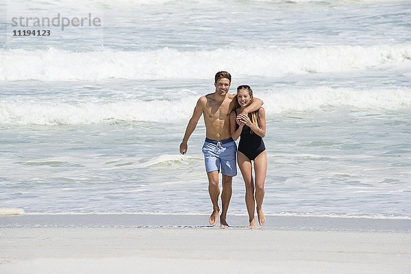 Porträt eines glücklichen Paares beim Spaziergang am Strand