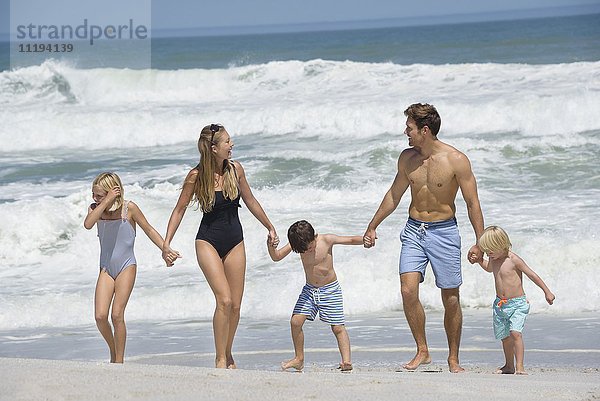 Glückliche Familie beim Spaziergang am Strand
