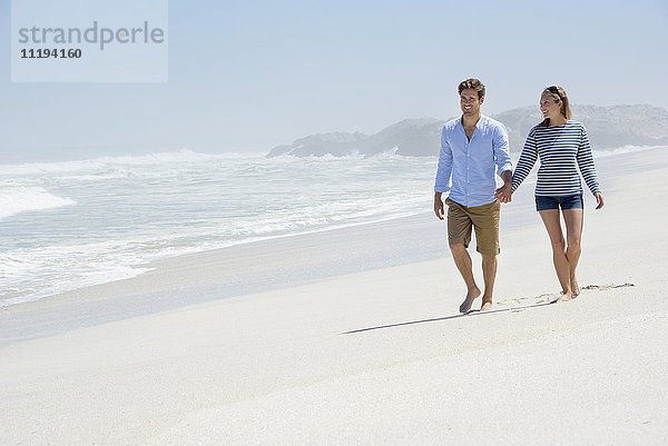 Glückliches Paar  das am Strand spazieren geht